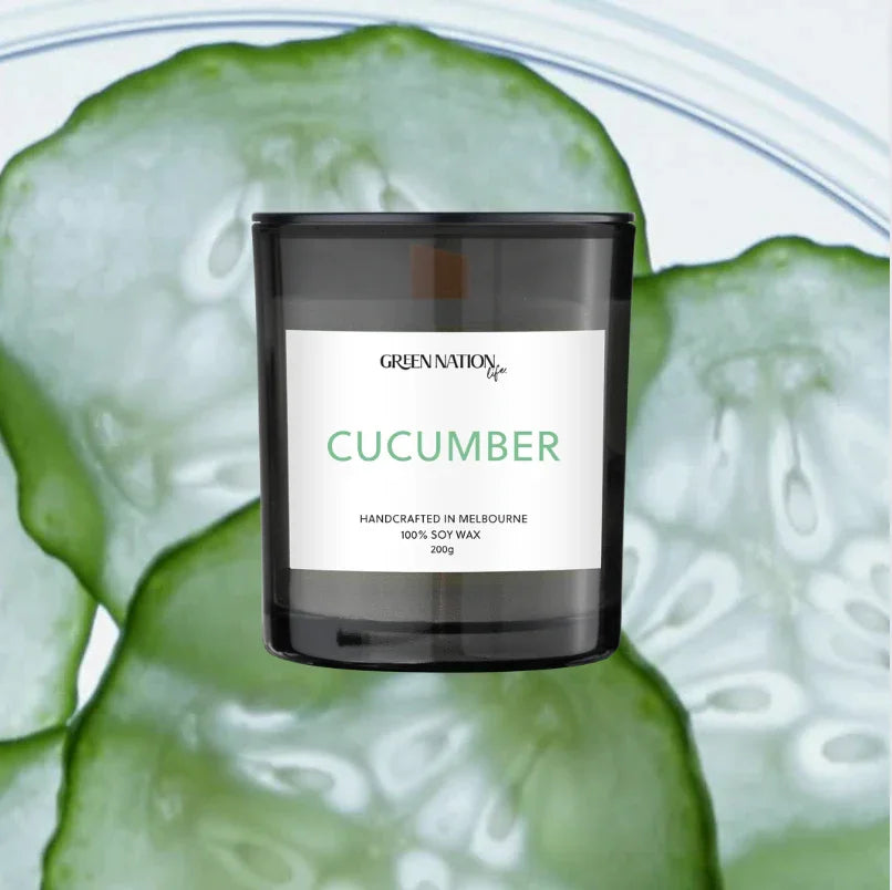Cucumber scented soy candle in black jar by Green Nation Life, with cucumber slices background